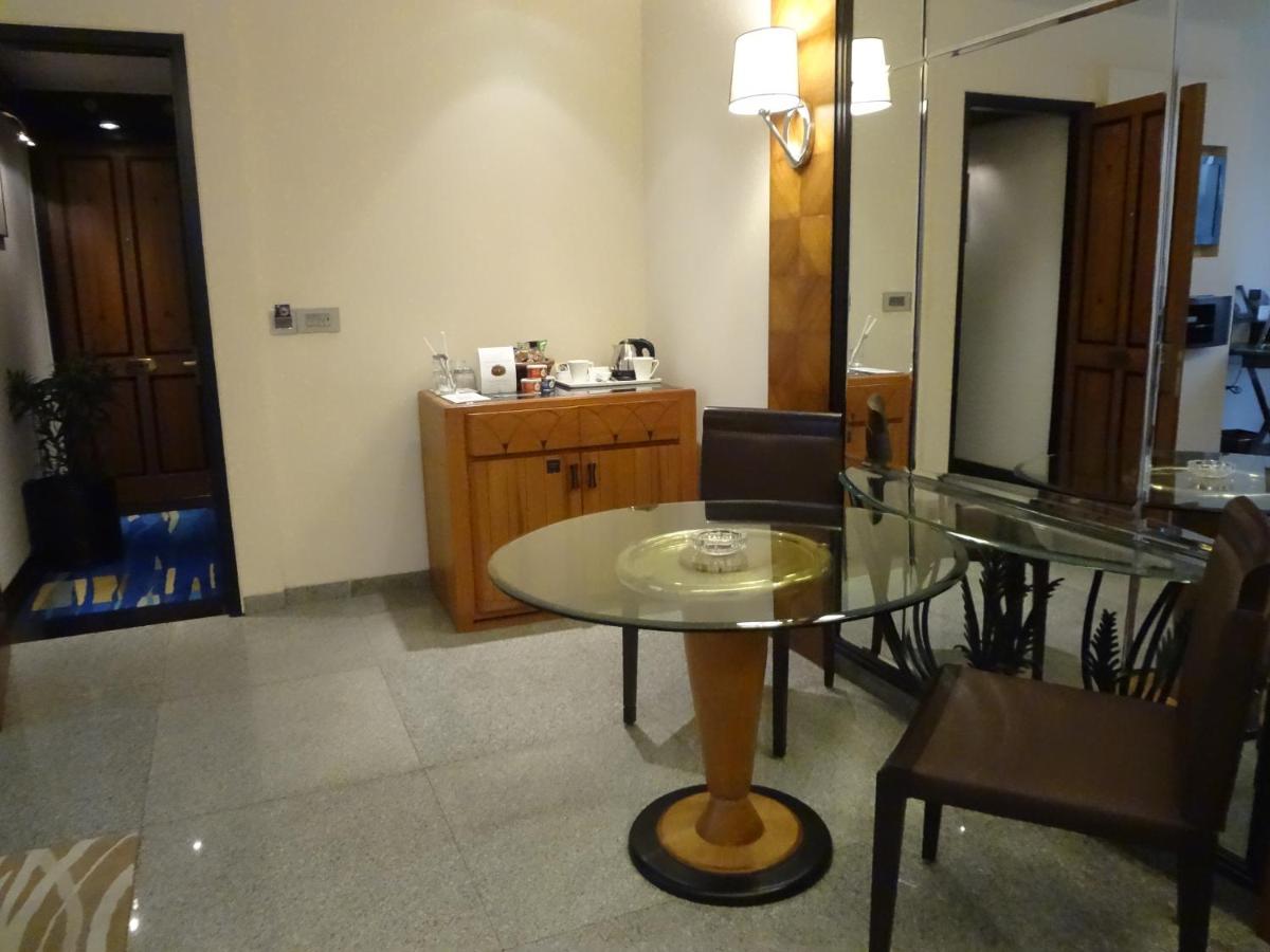 a dining room with a glass table and chairs at Hotel Marine Plaza in Mumbai