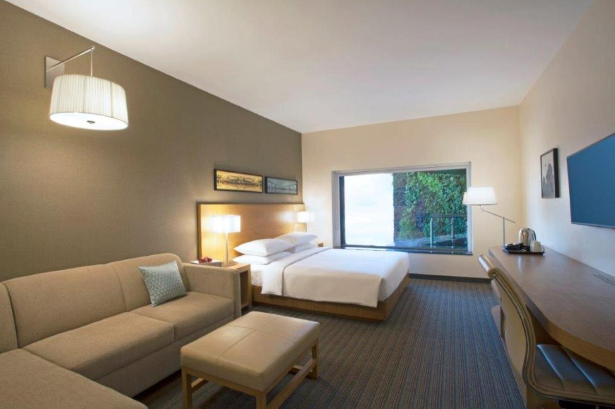 a hotel room with a bed and a couch at Hyatt Place Hyderabad Banjara Hills in Hyderabad