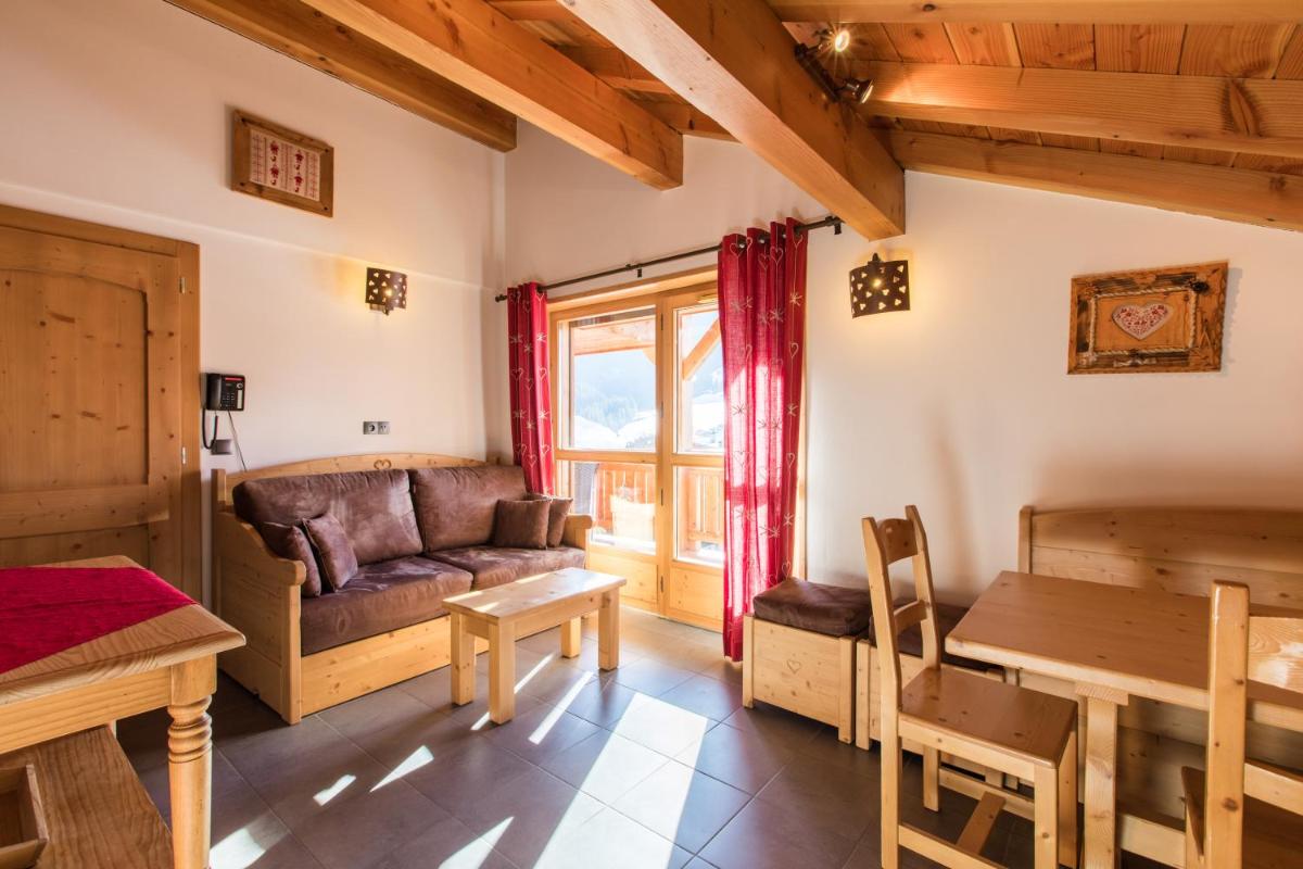 un salon avec un canapé et une table dans l'établissement Les Chalets de La Griyotire, à Praz-sur-Arly