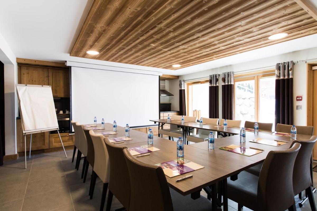 une grande salle de conférence avec une longue table et des chaises dans l'établissement Les Chalets de La Griyotire, à Praz-sur-Arly 109 autres photos