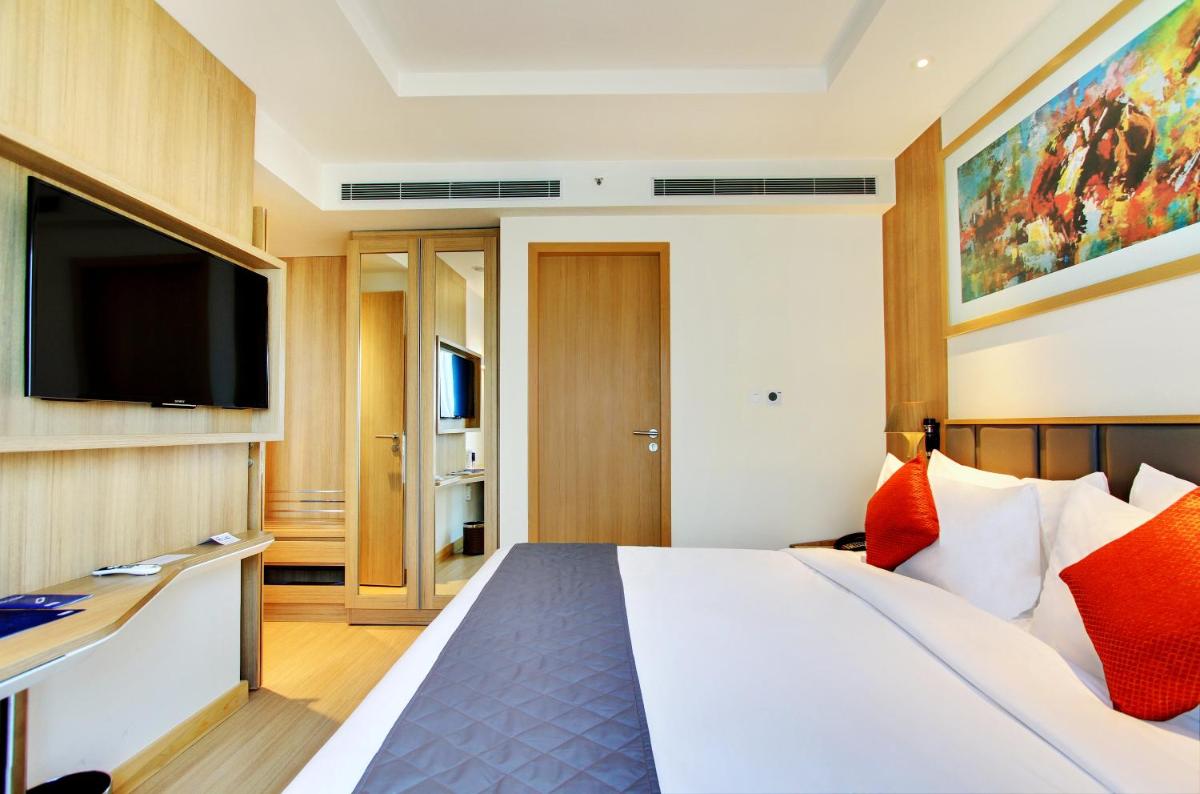 a hotel room with a bed and a flat screen tv at Holiday Inn Bengaluru Racecourse by IHG in Bengaluru a hotel room with a bed and a flat screen tv at Holiday Inn Bengaluru Racecourse by IHG in Bengaluru