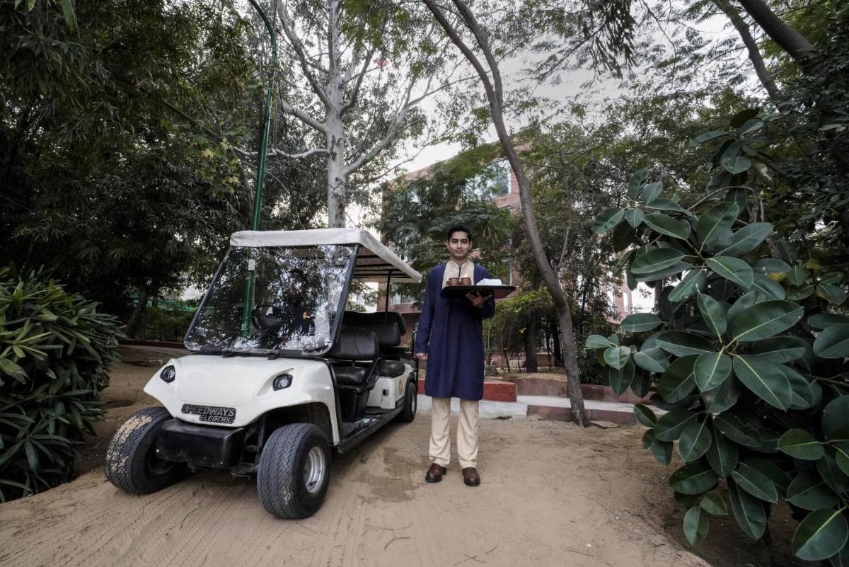 a man is standing next to a golf cart at Brij Nest, Jaipur - An All Suite Boutique Hotel in Jaipur
