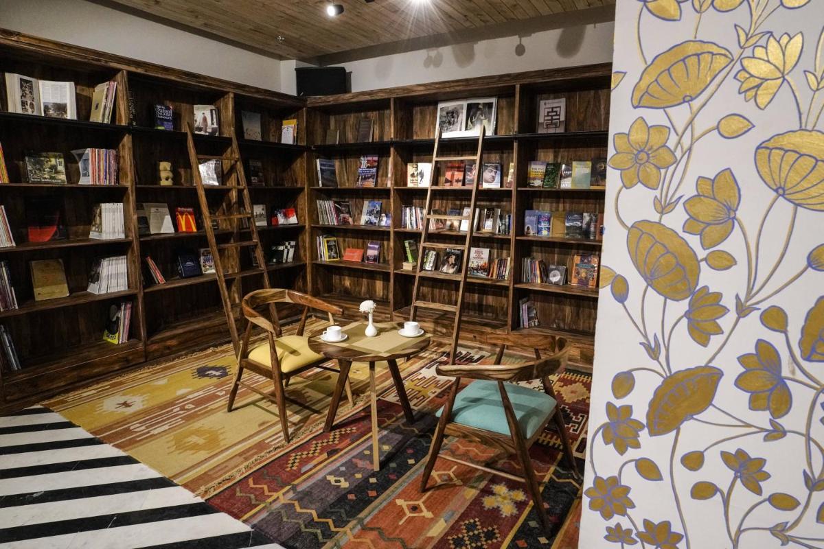 a library with a table and chairs and bookshelves at Brij Nest, Jaipur - An All Suite Boutique Hotel in Jaipur