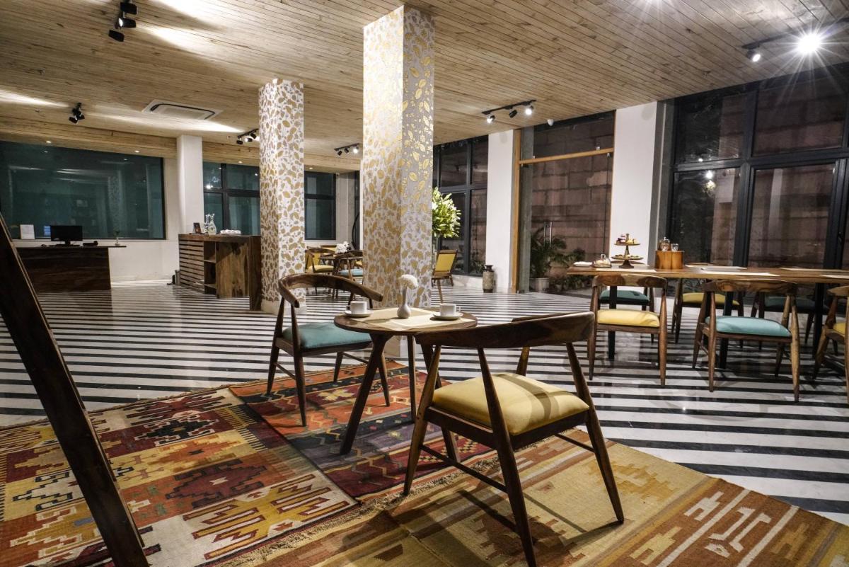 a restaurant with tables and chairs in a room at Brij Nest, Jaipur - An All Suite Boutique Hotel in Jaipur