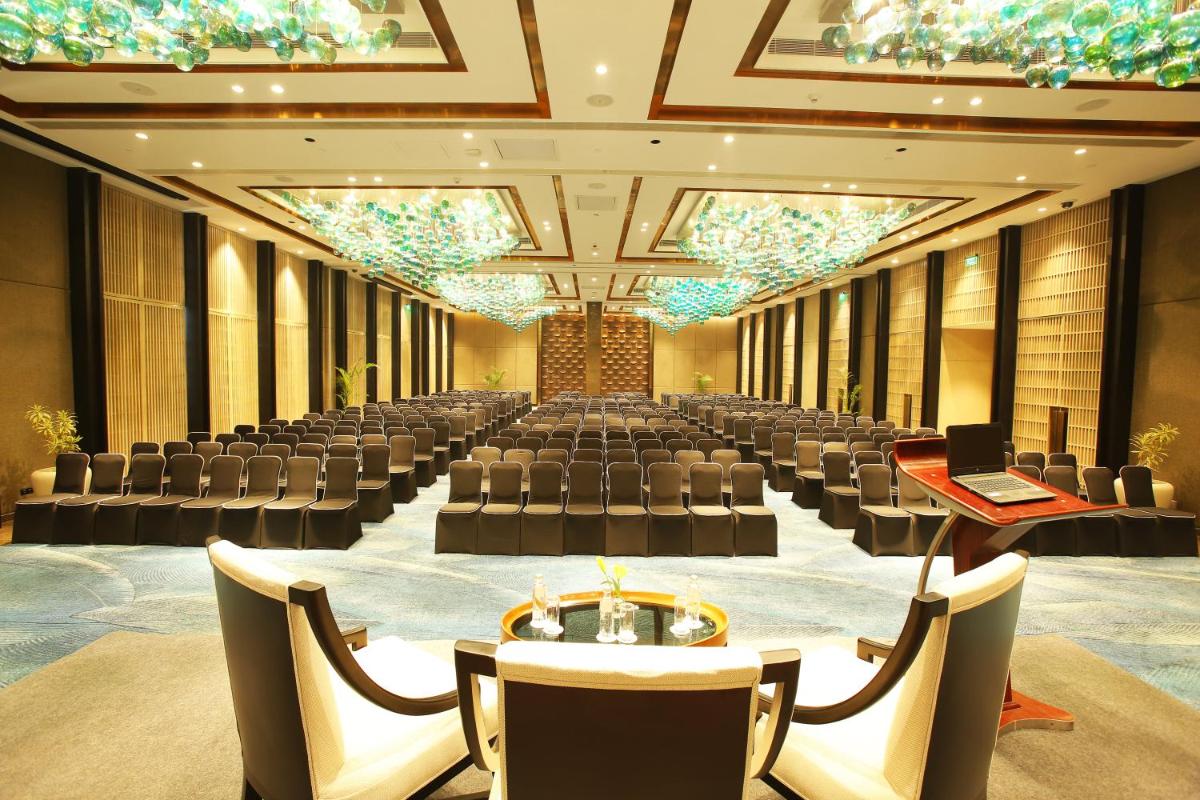 a large banquet hall with chairs and tables and a laptop at Crowne Plaza New Delhi Mayur Vihar Noida by IHG in New Delhi