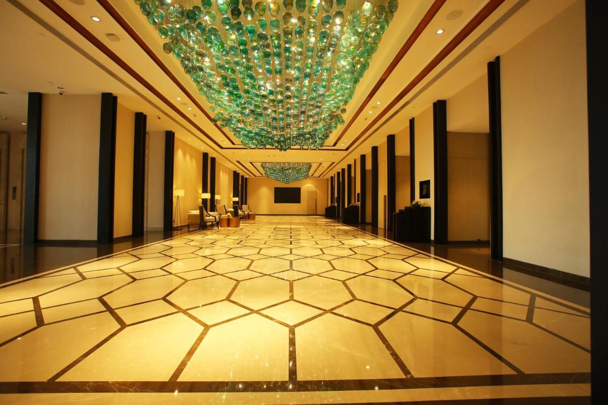 a long hallway with a chandelier and a large building at Crowne Plaza New Delhi Mayur Vihar Noida by IHG in New Delhi