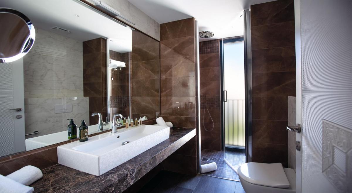 Un baño con bañera, lavabo e inodoro. en Boutique Hotel Élke Spa Superior, en Sant Feliu de Guíxols