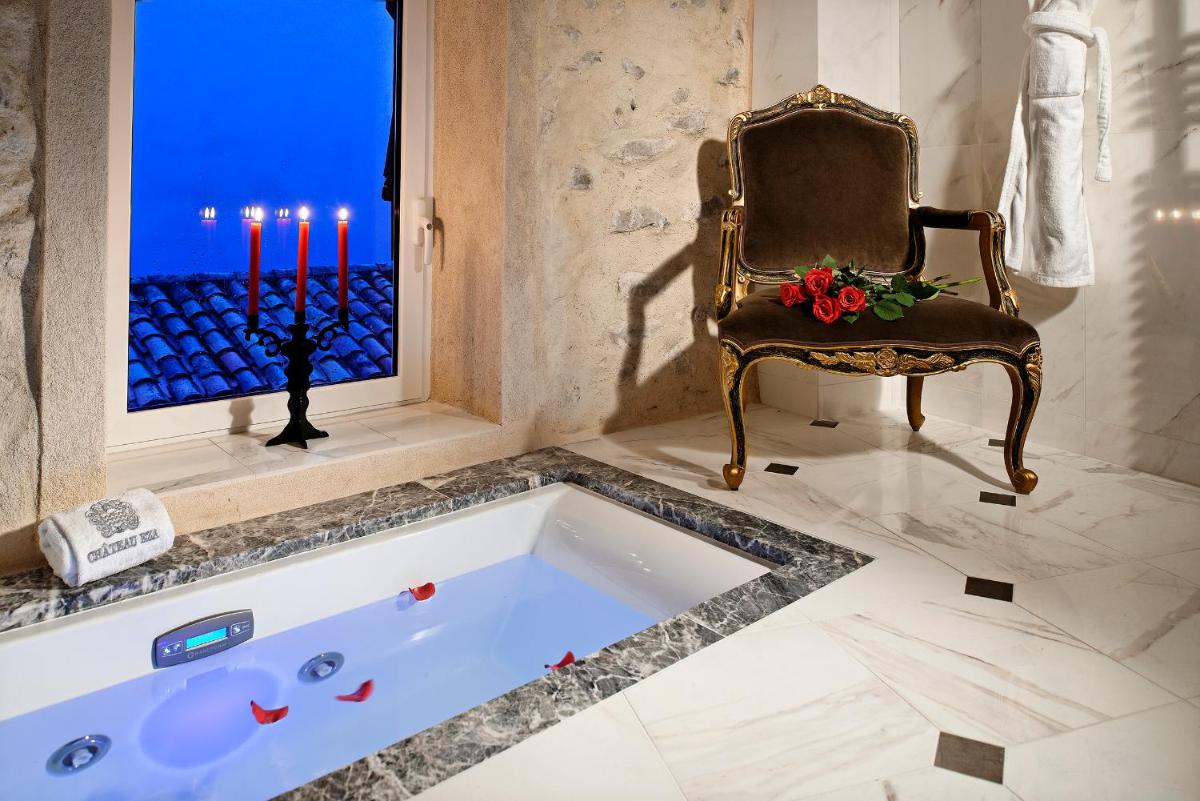 - une baignoire dans une pièce avec une chaise et des bougies dans l'établissement Chateau Eza, à Èze 37 autres photos