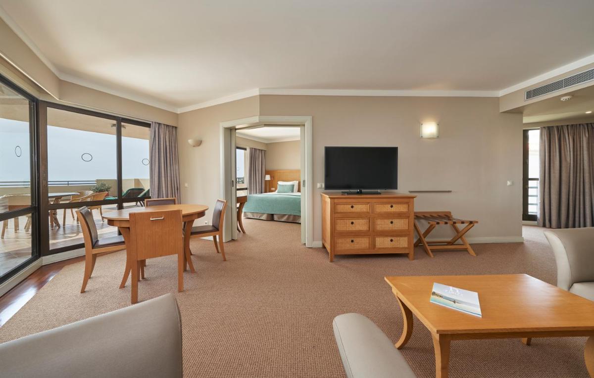 um quarto de hotel com uma área de estar com televisão em Suite Hotel Eden Mar - PortoBay no Funchal