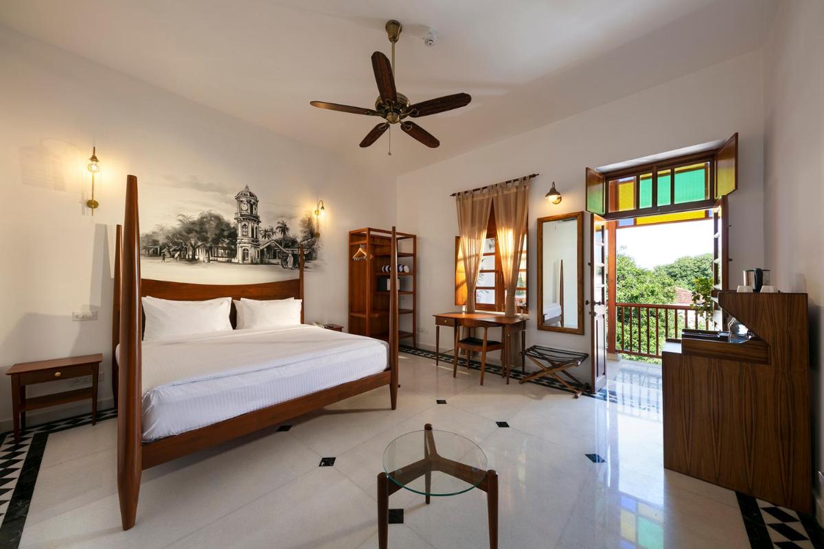 a bedroom with a bed and a ceiling fan at Grand Hotel D'Europe in Puducherry