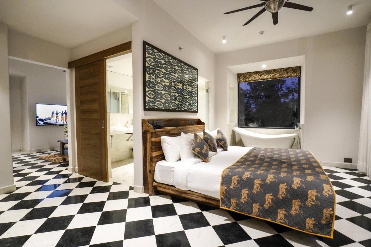 a bedroom with a bed and a checkered floor at Brij Nest, Jaipur - An All Suite Boutique Hotel in Jaipur