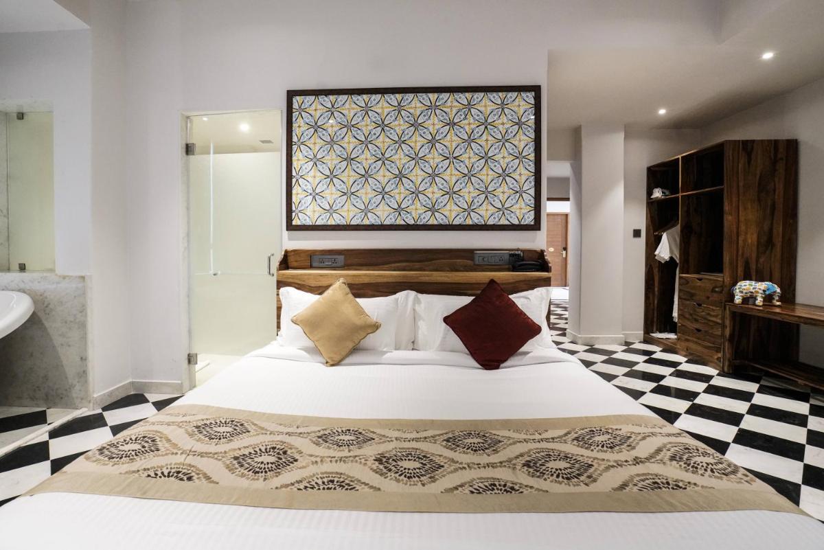 a bedroom with a large bed and a checkered floor at Brij Nest, Jaipur - An All Suite Boutique Hotel in Jaipur