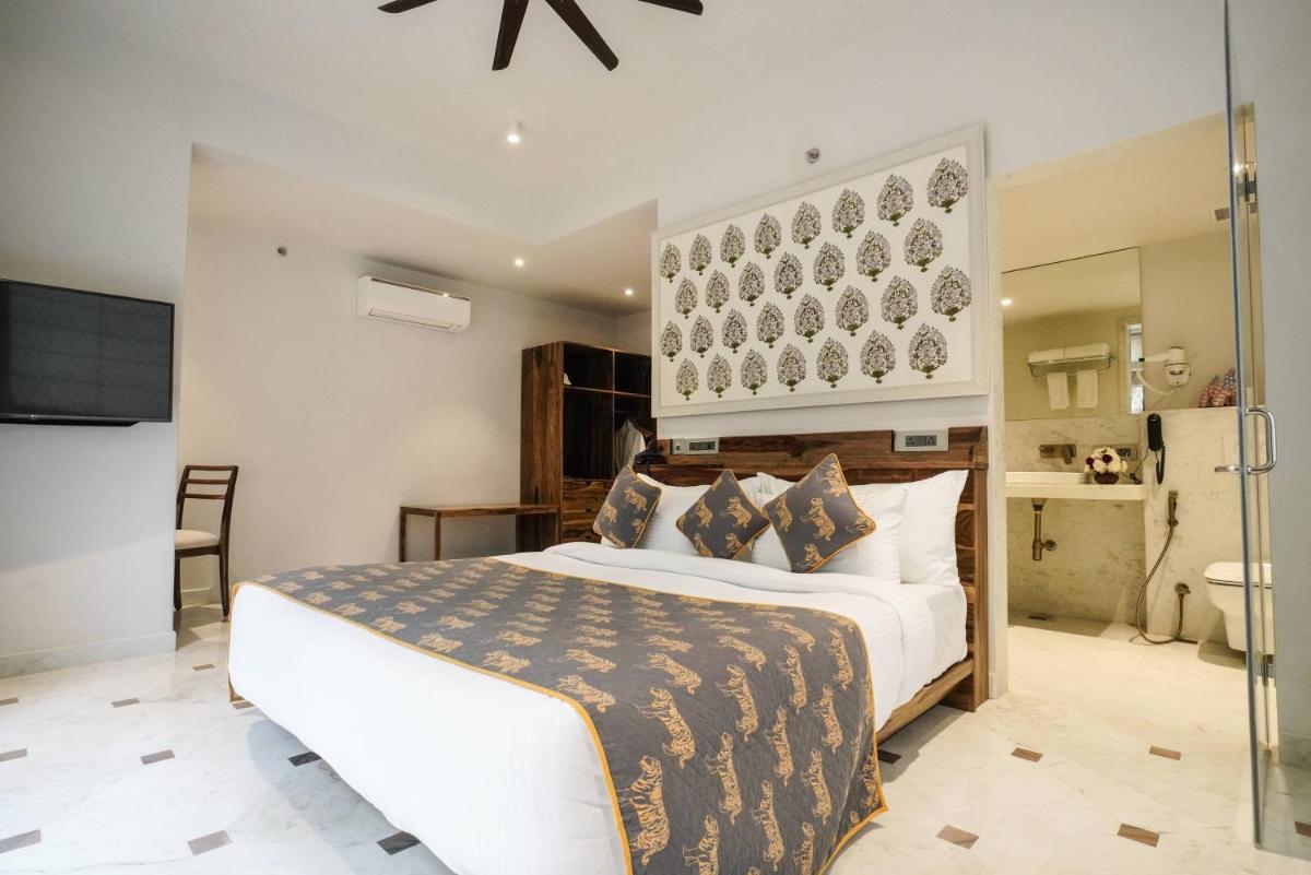 a bedroom with a large bed and a bathroom at Brij Nest, Jaipur - An All Suite Boutique Hotel in Jaipur