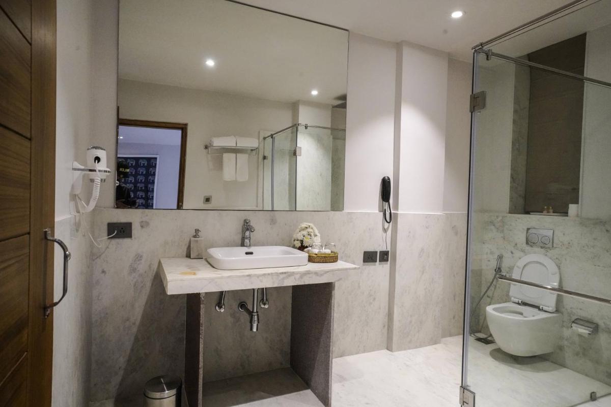 a bathroom with a sink and a shower and a toilet at Brij Nest, Jaipur - An All Suite Boutique Hotel in Jaipur