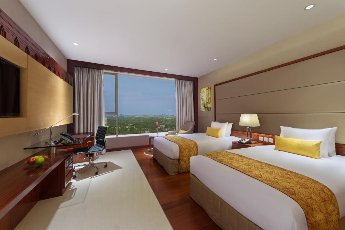 a hotel room with two beds and a television at Crowne Plaza Kochi by IHG in Cochin