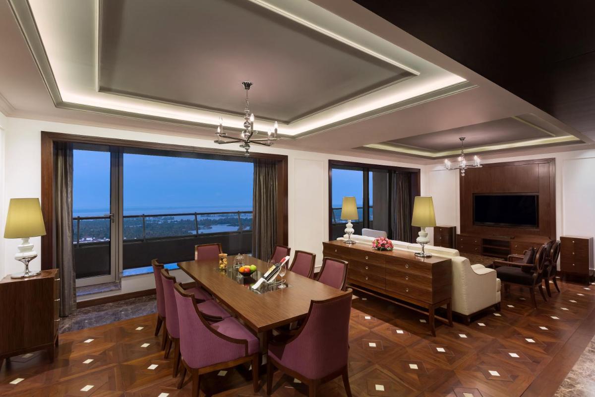 a dining room with a table and chairs and a large window at Crowne Plaza Kochi by IHG in Cochin
