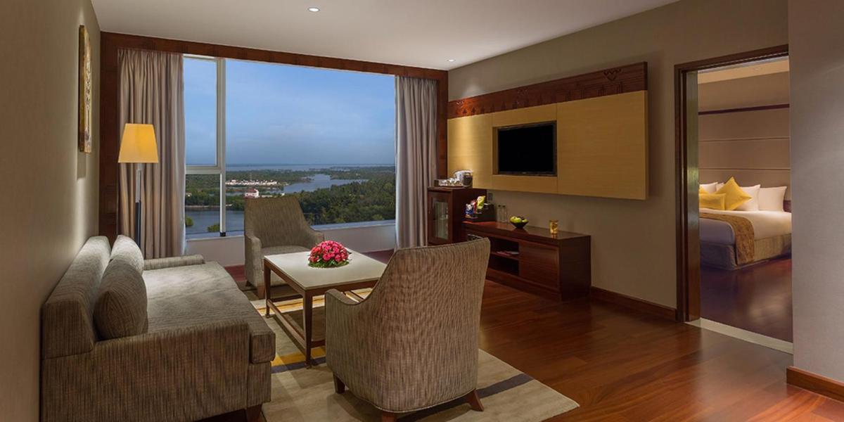 a hotel room with a bedroom and a living room at Crowne Plaza Kochi by IHG in Cochin