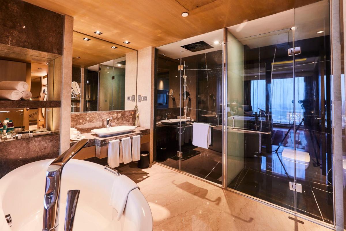 a bathroom with a tub and a glass shower at Crowne Plaza New Delhi Rohini by IHG in New Delhi a bathroom with a tub and a glass shower at Crowne Plaza New Delhi Rohini by IHG in New Delhi