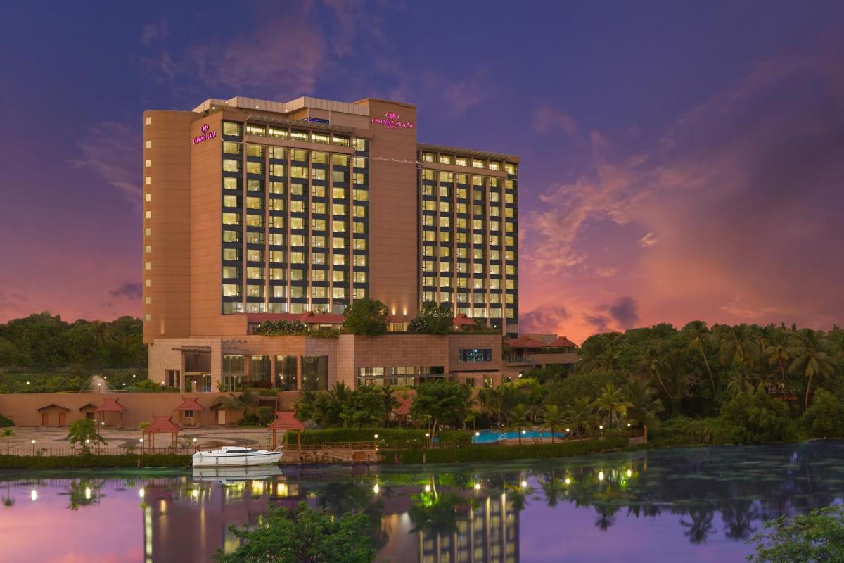 a hotel building with a reflection in the water at Crowne Plaza Kochi by IHG in Cochin