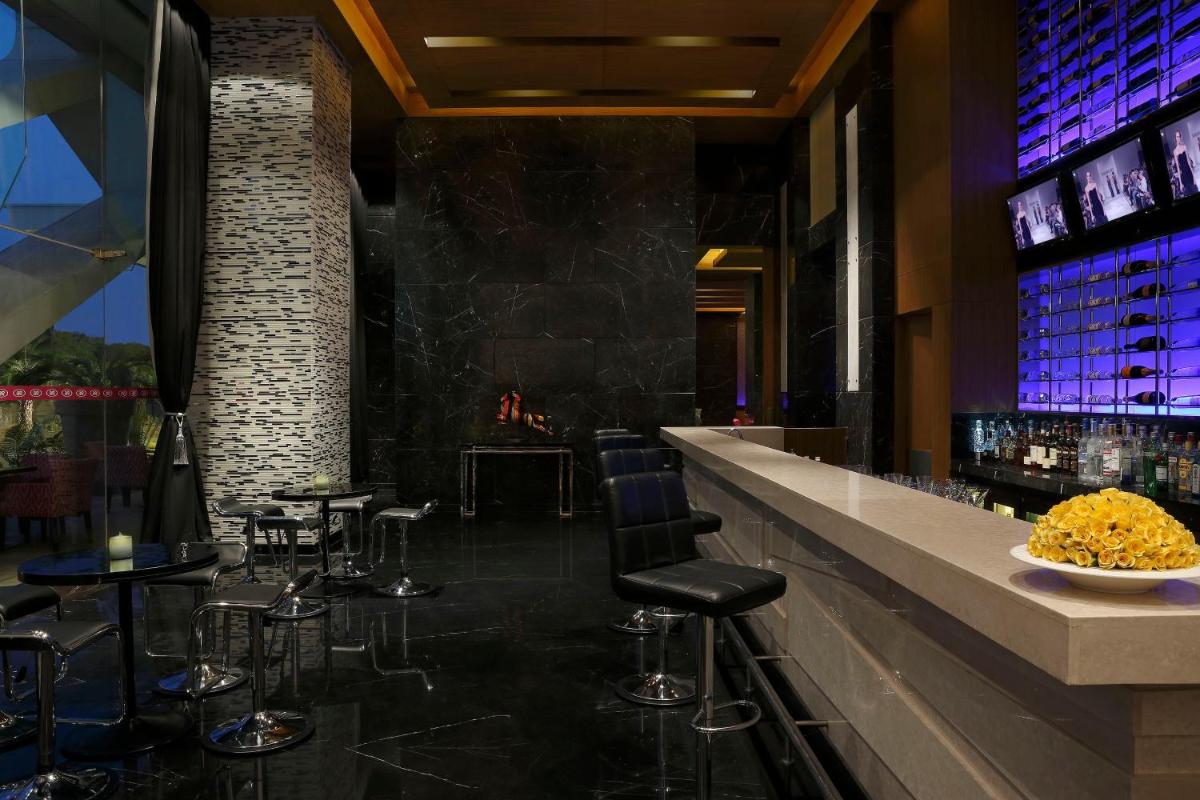 a bar with stools and a counter in a restaurant at InterContinental Jaipur Tonk Road by IHG in Jaipur