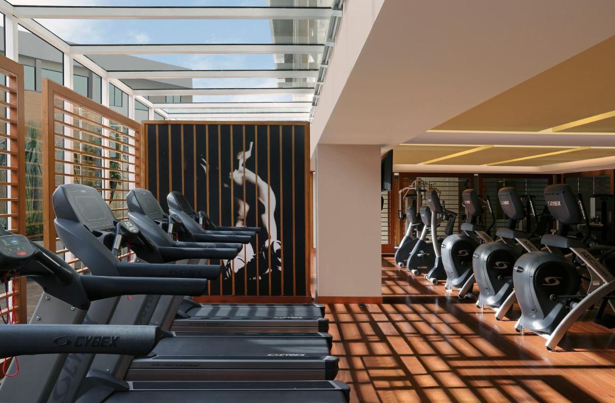 a gym with rows of treadmills and elliptical machines at InterContinental Jaipur Tonk Road by IHG in Jaipur