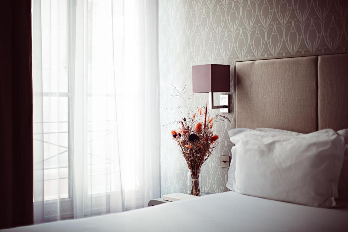 Un ou plusieurs lits dans un hébergement de l'établissement Monsieur Cadet Hotel & Spa