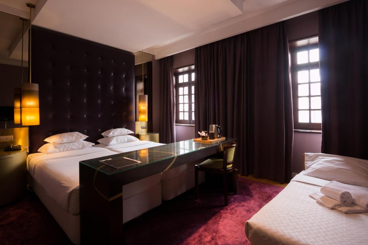 um quarto de hotel com duas camas e uma escrivaninha em Hotel Meira em Vila Praia de Âncora