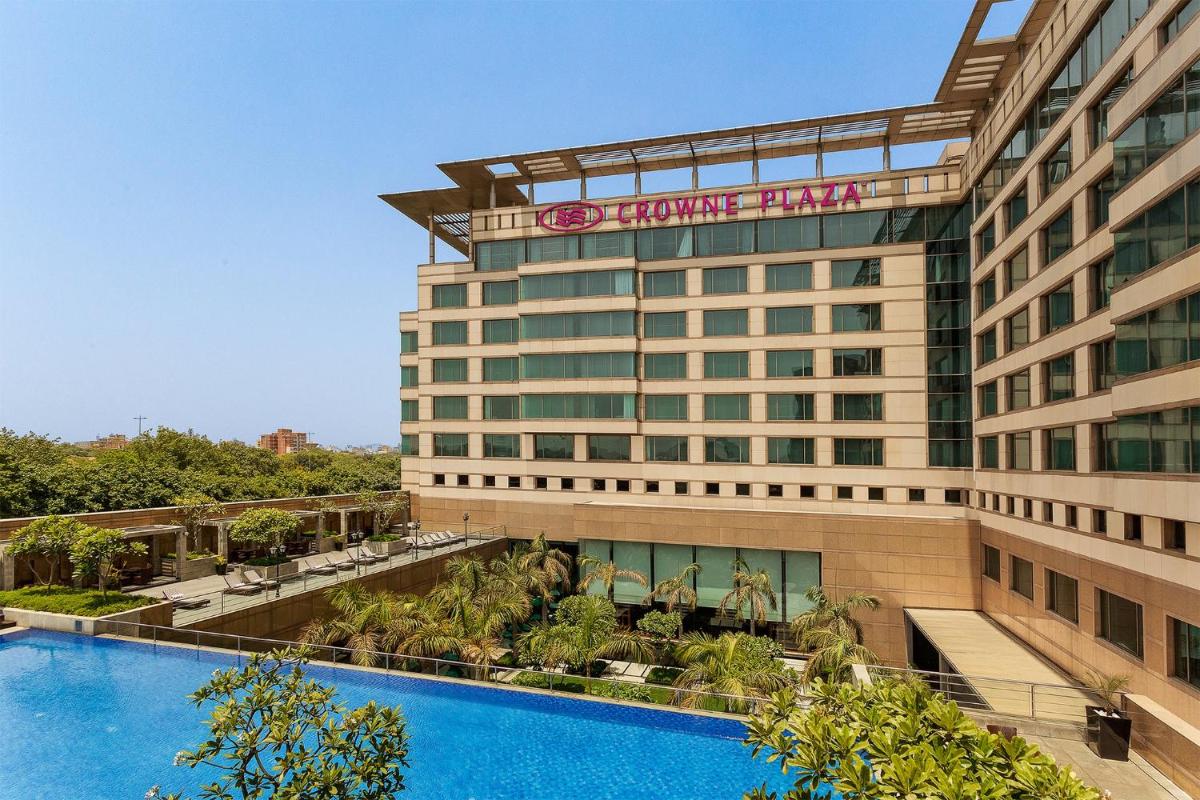 a hotel with a swimming pool in front of a building at Crowne Plaza Today Gurugram by IHG in Gurgaon