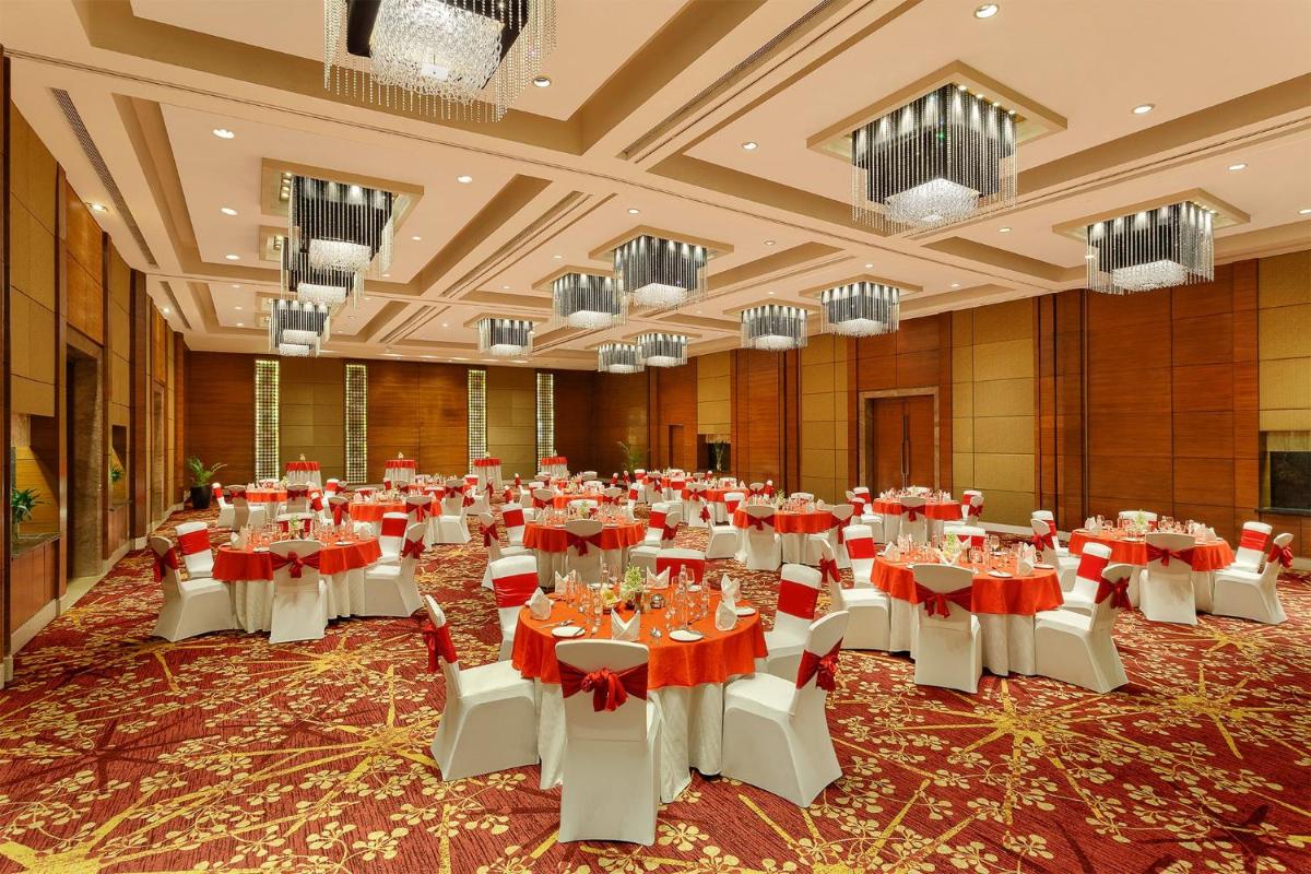 a banquet hall with tables and chairs and chandeliers at Crowne Plaza Today Gurugram by IHG in Gurgaon