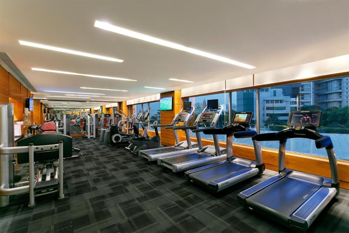 a gym with a row of treadmills and machines at Crowne Plaza Today Gurugram by IHG in Gurgaon