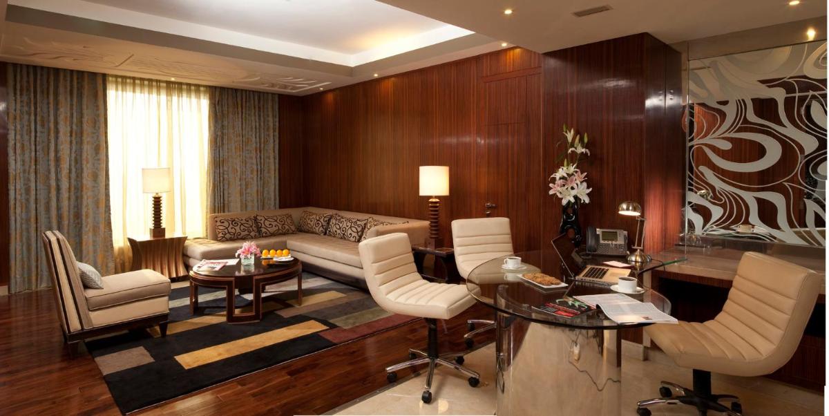 a living room with a couch and a table and chairs at Crowne Plaza New Delhi Okhla by IHG in New Delhi