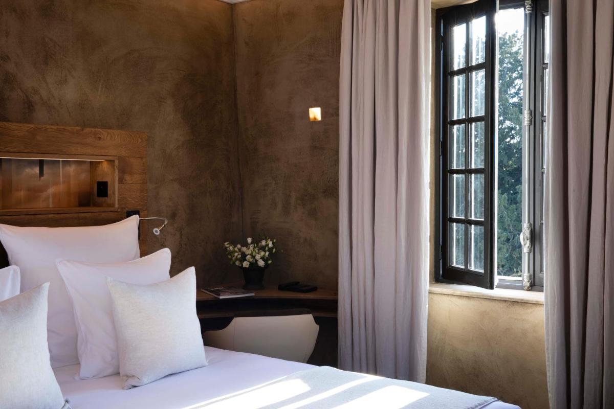 Un ou plusieurs lits dans un hébergement de l'établissement Hôtel Saint-Delis - La Maison du Peintre - Relais & Châteaux