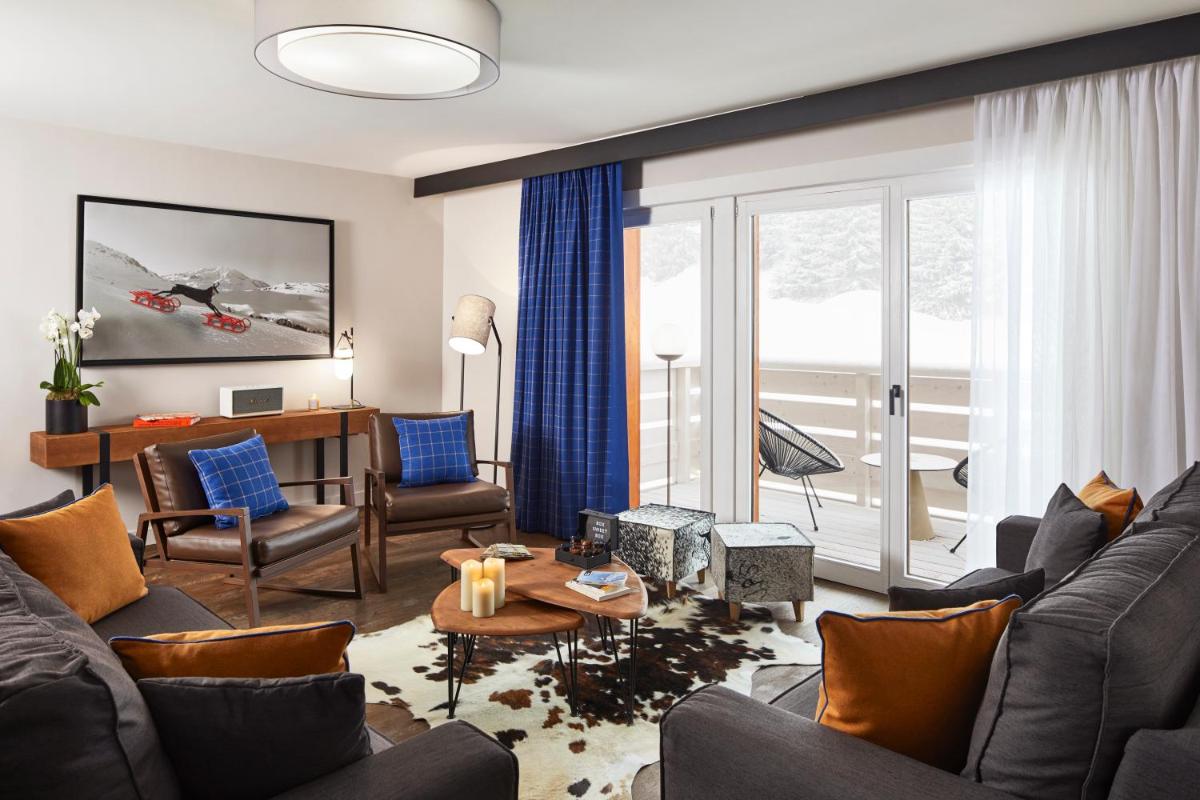 un salon avec un canapé et une table dans l'établissement Ecrin Blanc Resort Courchevel - Aquapark, à Courchevel