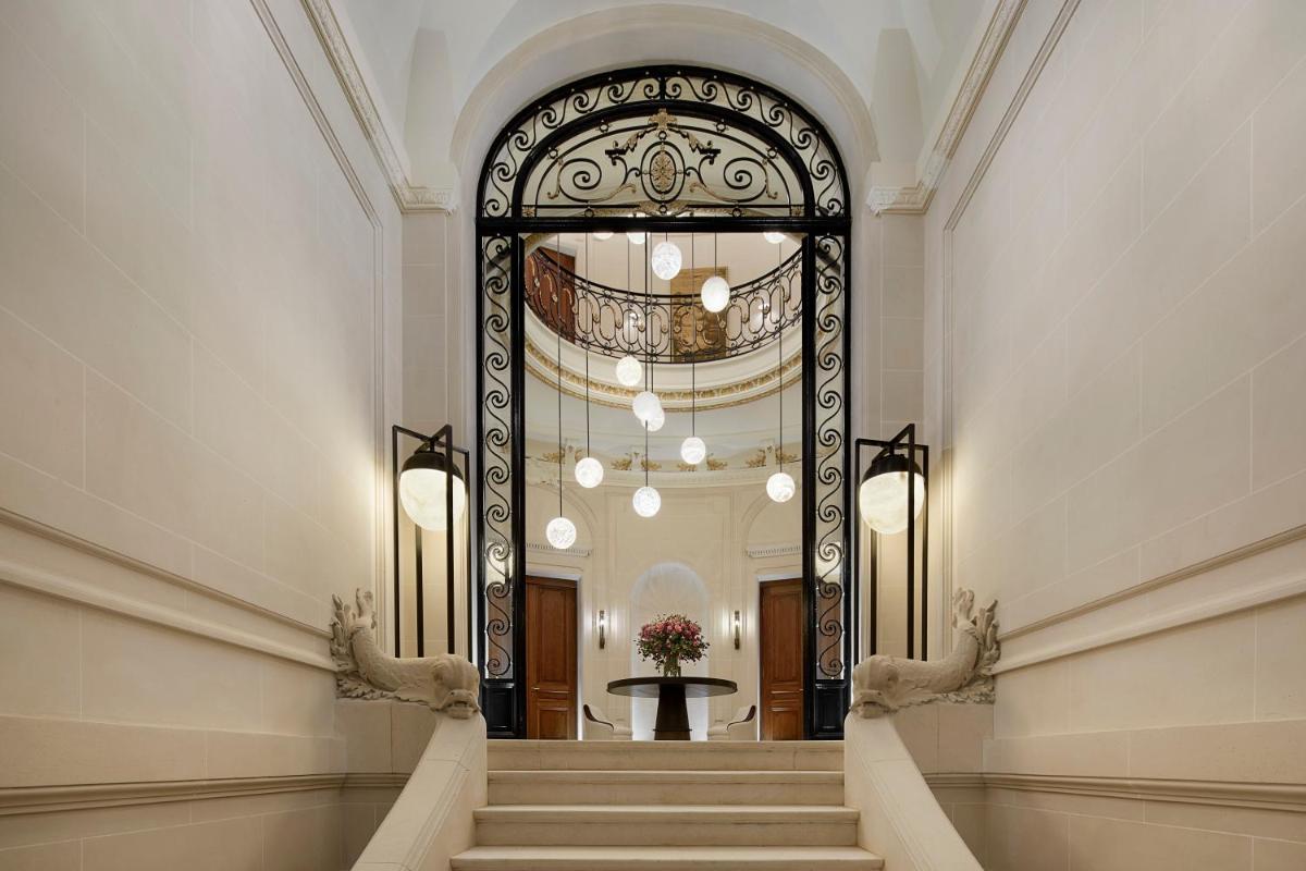 un couloir avec un escalier dans un immeuble dans l'établissement Maison Villeroy, à Paris