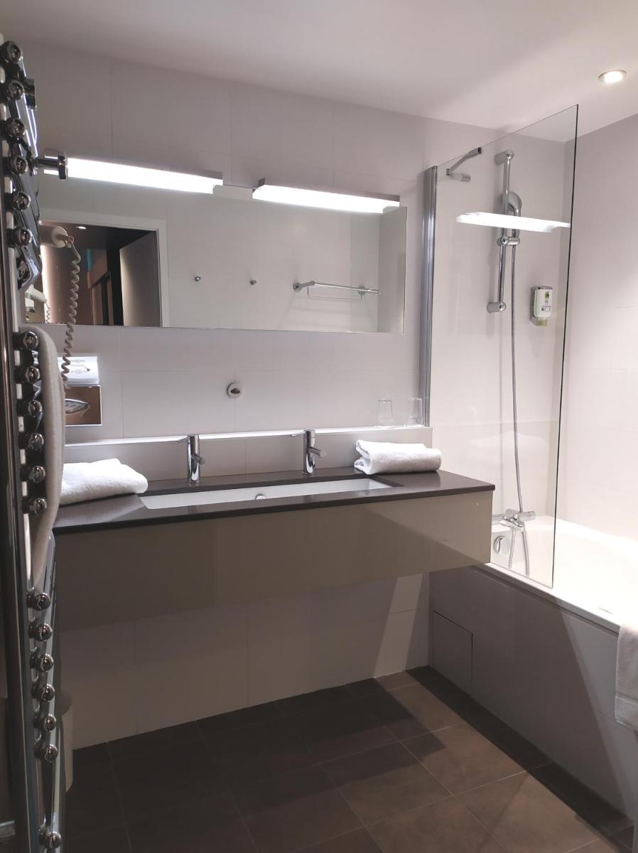 une salle de bain avec un lavabo et un miroir dans l'établissement Best Western Aquakub, à Aix-les-Bains