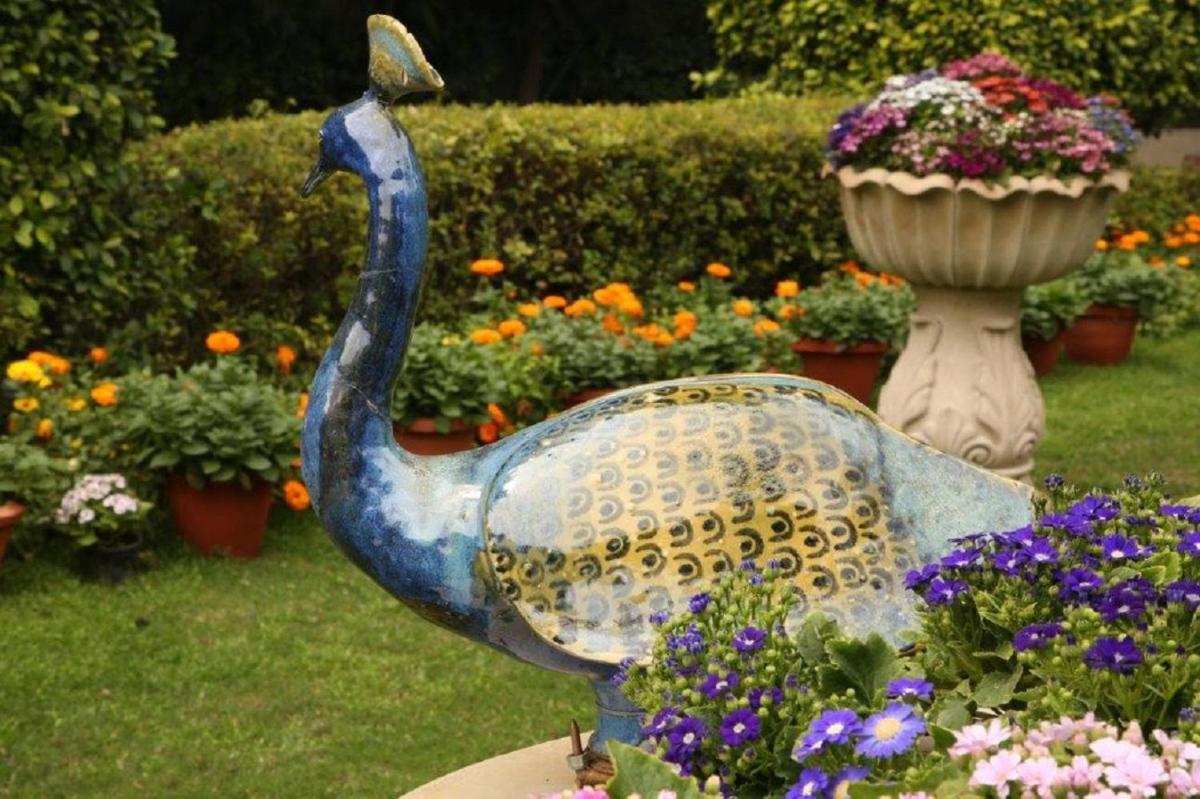 a statue of a peacock in a garden with flowers at Taj Palace, New Delhi in New Delhi a statue of a peacock in a garden with flowers at Taj Palace, New Delhi in New Delhi