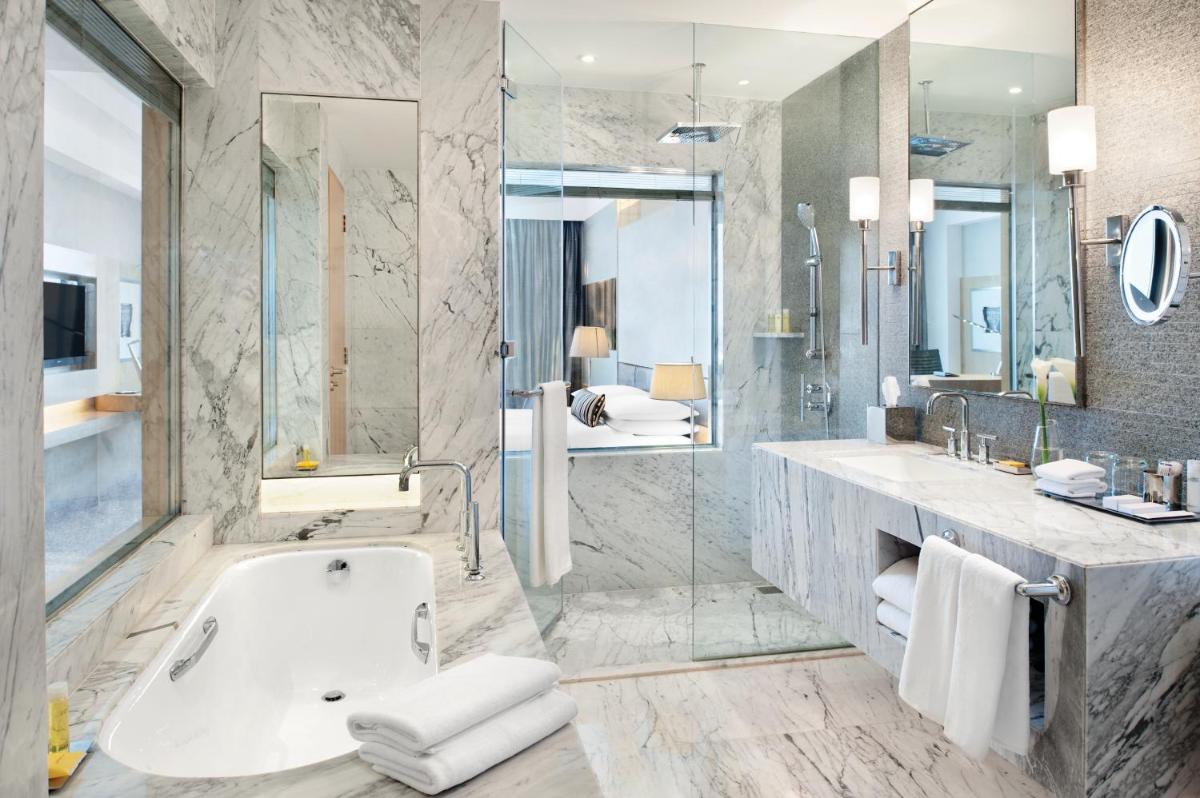 a bathroom with a tub and a sink and a shower at Hyatt Regency Gurgaon in Gurgaon