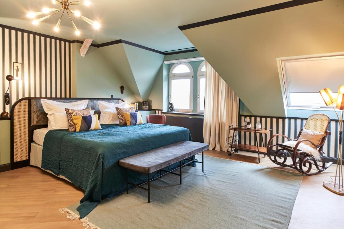 Schlafzimmer mit einem Bett mit einer Bank in der Unterkunft Cora Apartments in Leipzig