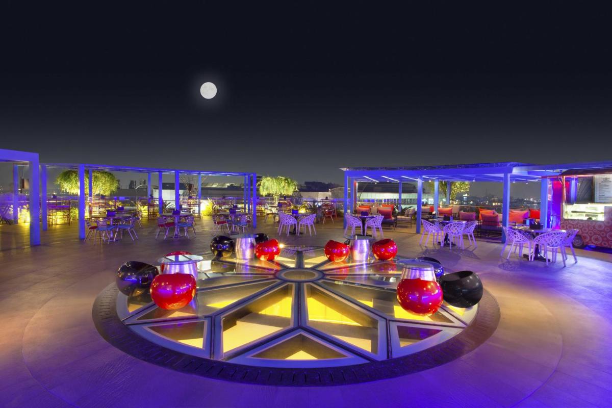 a room with tables and chairs and a table with lights at Hyatt Place Hyderabad Banjara Hills in Hyderabad