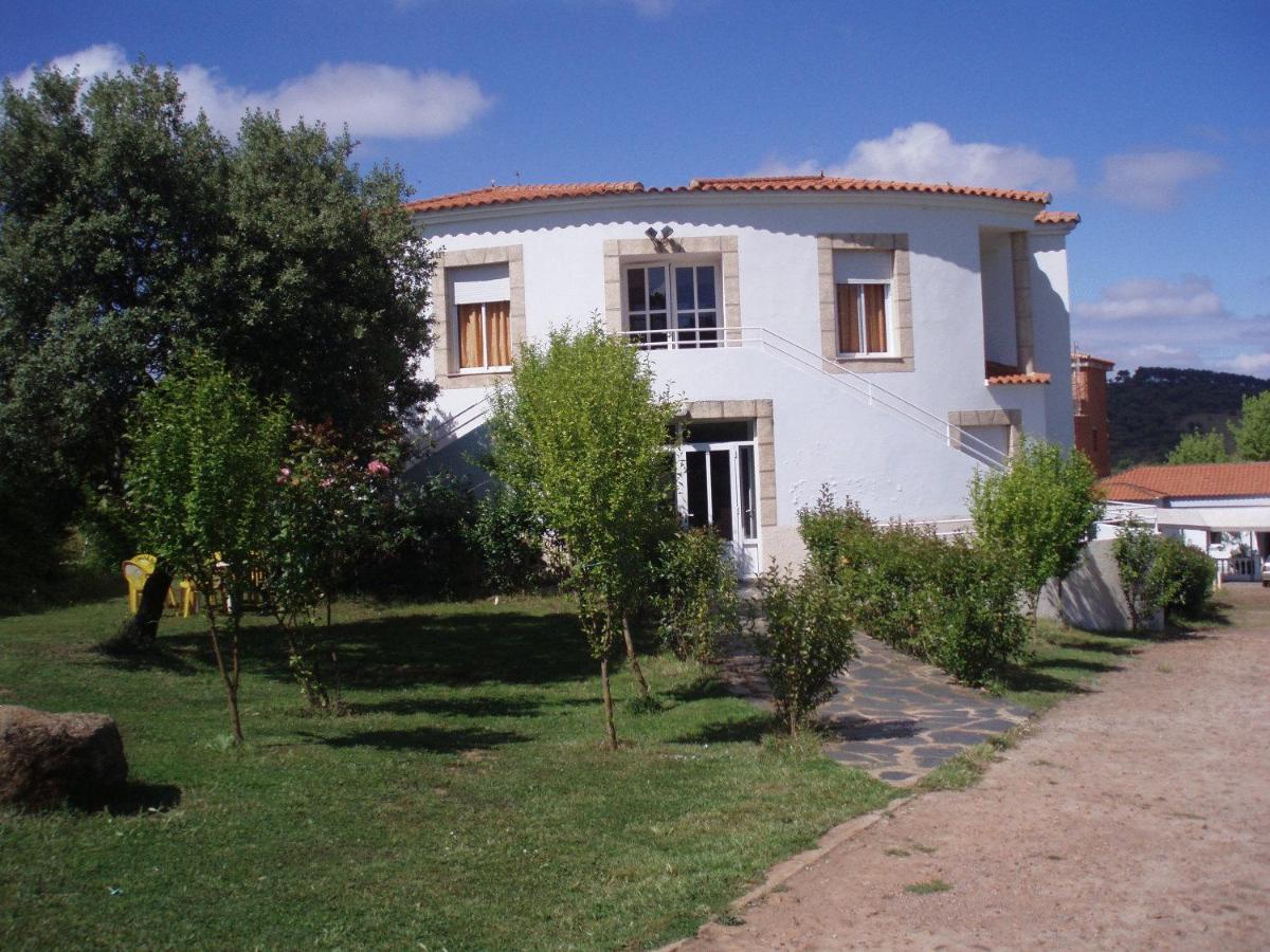 una casa blanca con árboles delante en Hotel Balneario Fuentes del Trampal, en Carmonita