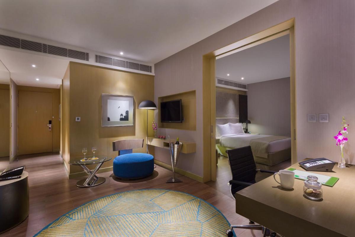 a hotel room with a bedroom with a bed and a desk at Holiday Inn New Delhi Aerocity by IHG in New Delhi