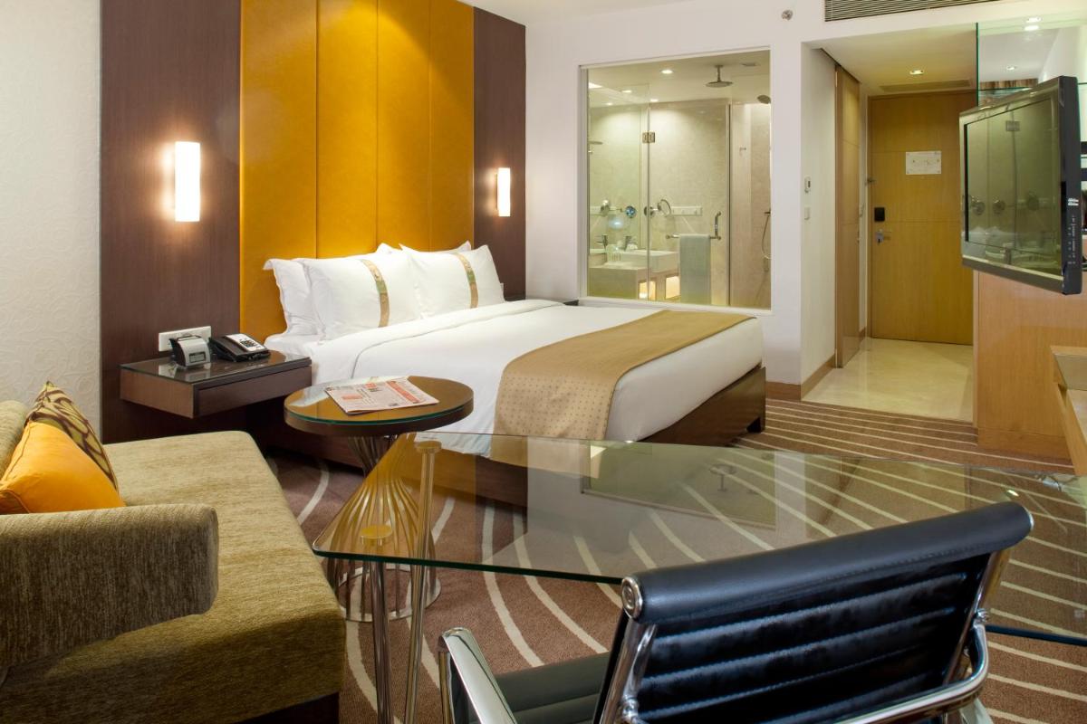 a hotel room with a large bed and a couch at Holiday Inn Mumbai International Airport by IHG in Mumbai