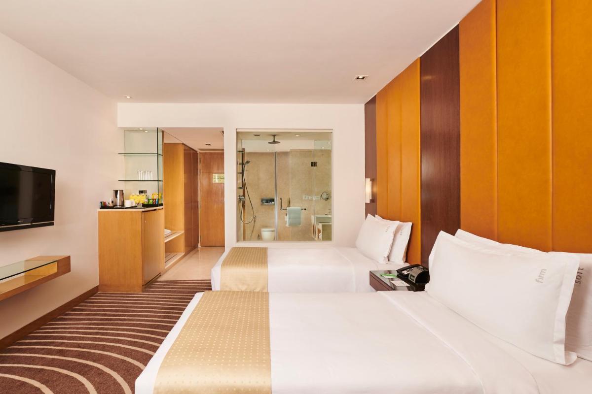 a hotel room with two beds and a television at Holiday Inn Mumbai International Airport by IHG in Mumbai