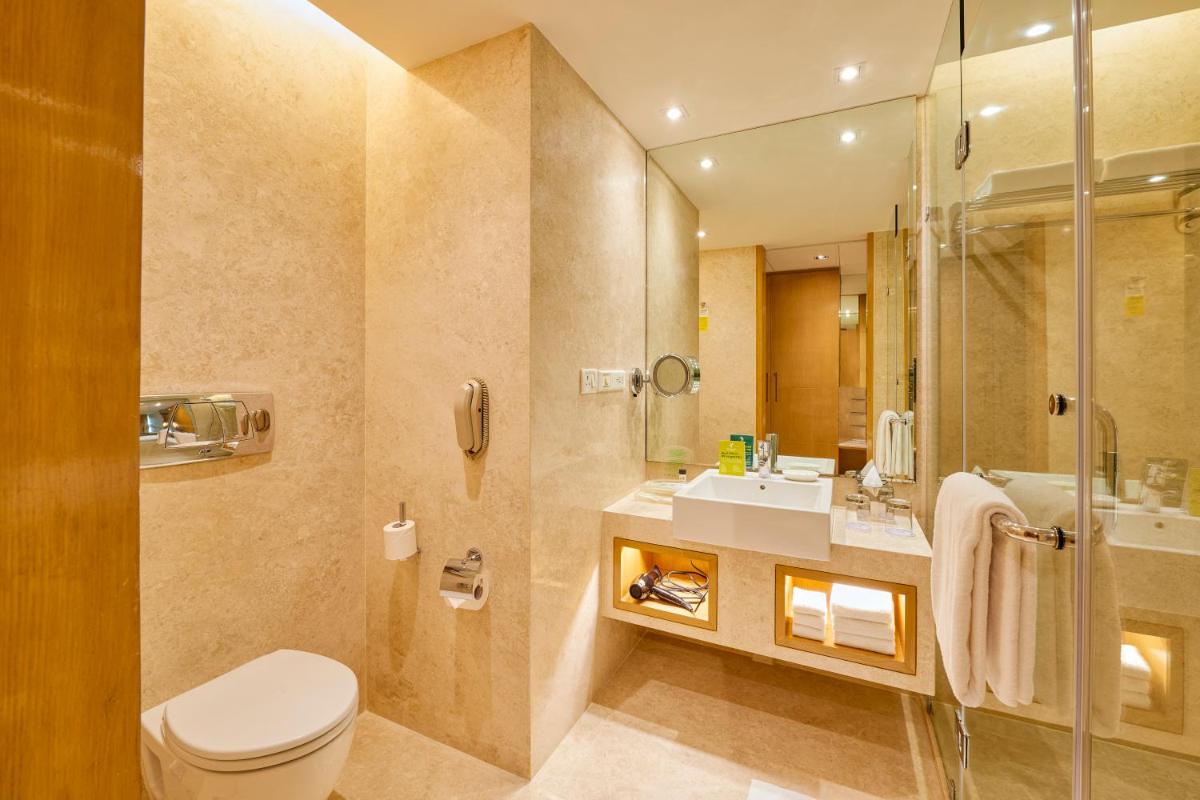 a bathroom with a toilet and a sink and a shower at Holiday Inn Mumbai International Airport by IHG in Mumbai