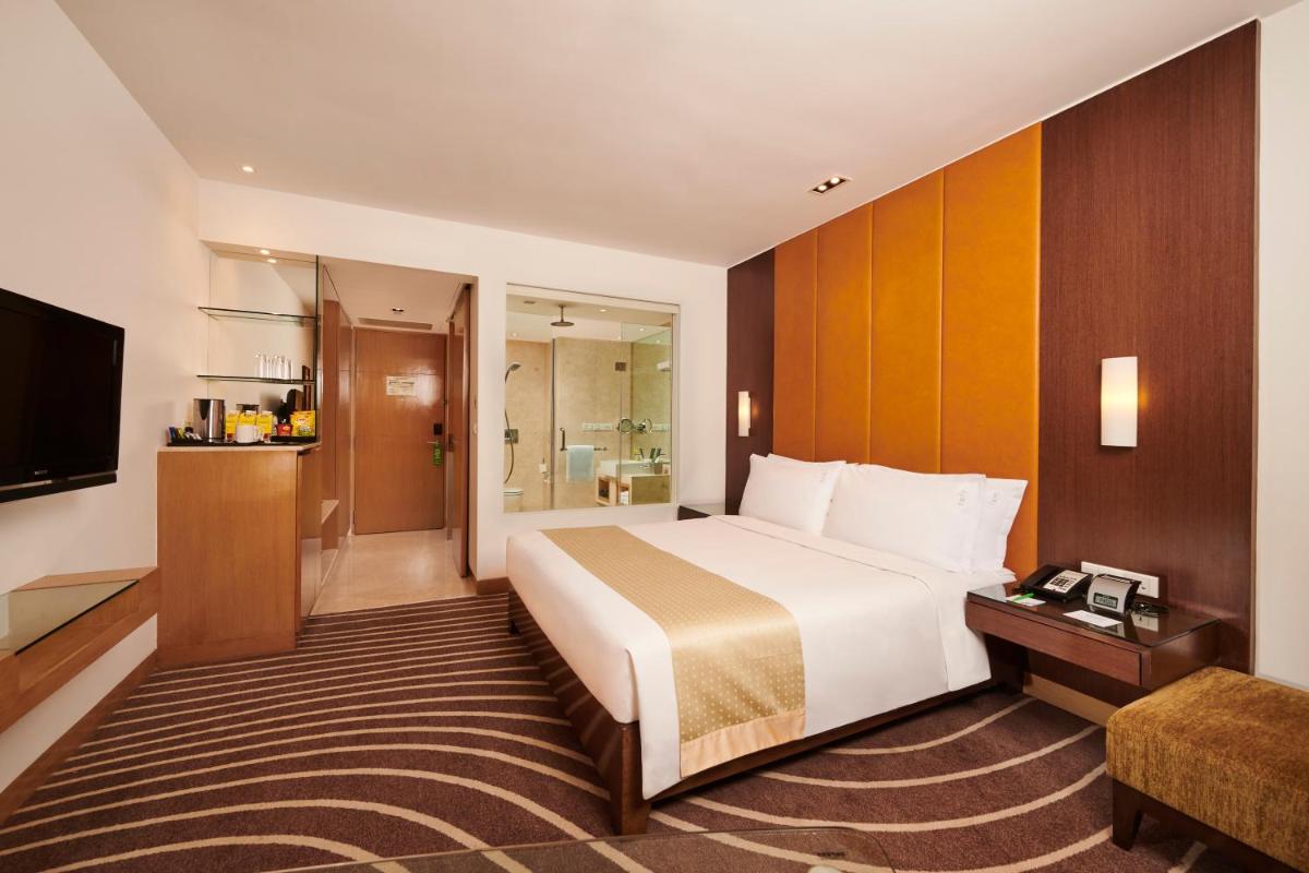 a hotel room with a bed and a television at Holiday Inn Mumbai International Airport by IHG in Mumbai