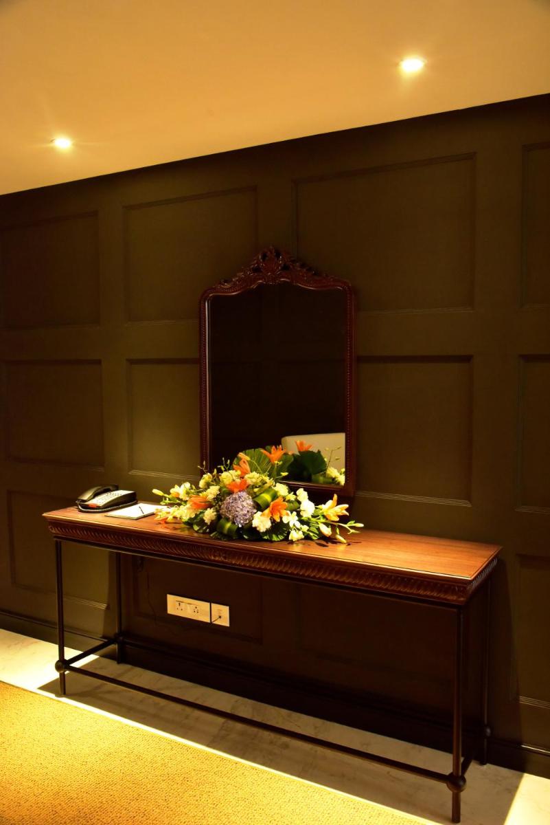 a table with a mirror and flowers on it at Radisson Hotel Shimla in Shimla