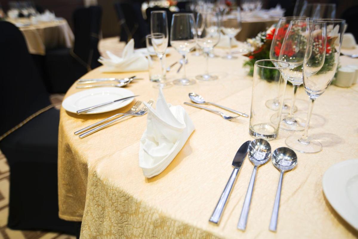 a table with wine glasses and silverware on it at Holiday Inn Chennai OMR IT Expressway by IHG in Chennai