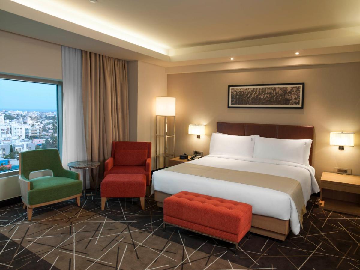 a hotel room with a bed and two chairs at Holiday Inn Chennai OMR IT Expressway by IHG in Chennai