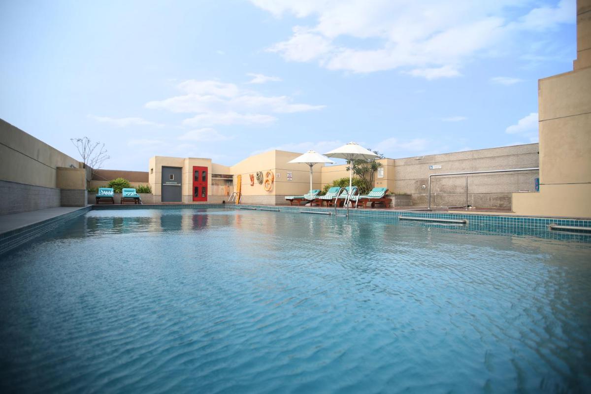 a swimming pool with blue water in front of a building at Holiday Inn Chennai OMR IT Expressway by IHG in Chennai