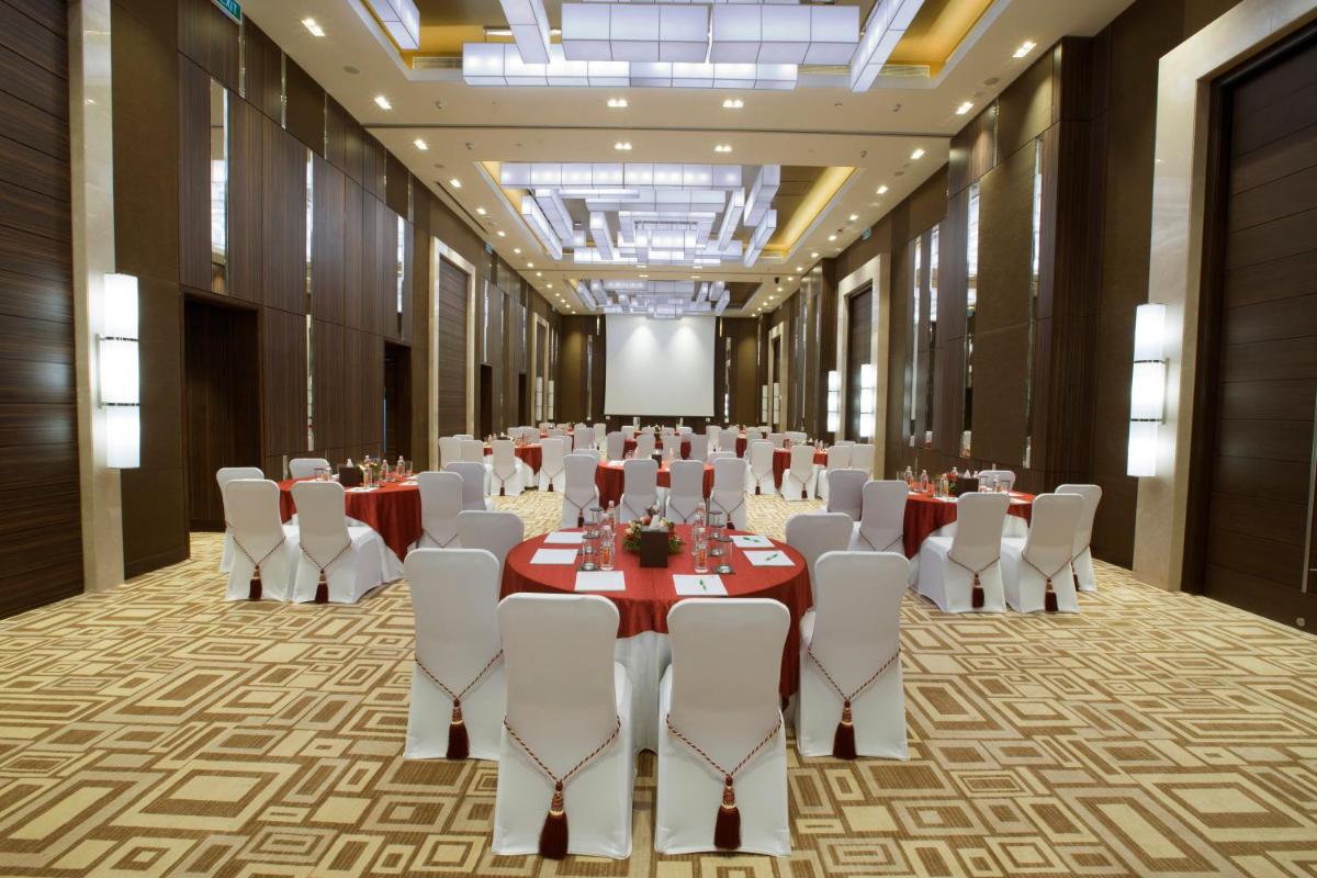 a large banquet hall with tables and white chairs at Holiday Inn Chennai OMR IT Expressway by IHG in Chennai